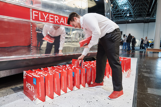 Mitarbeiter verteilen auf einer B2B-Messe Goodie-Bags